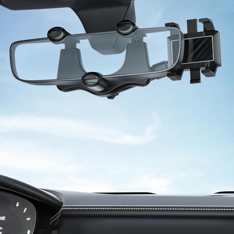 Rearview mirror phone holder clamped onto a car's rear-view mirror, seen from the driver's seat with the dashboard below