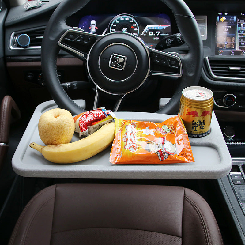 DeskLoop tray hooked over a steering wheel holding food