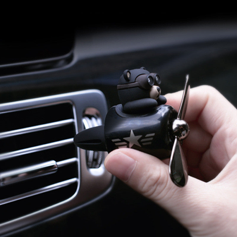Hand clipping the aviator bear diffuser onto a car dashboard air vent