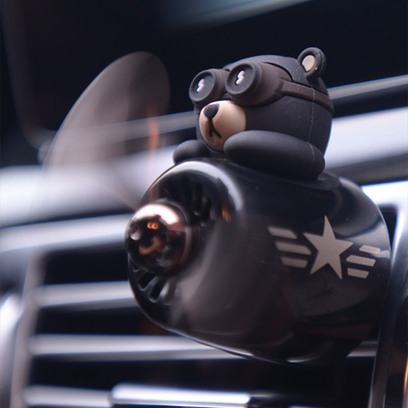 Aviator bear air freshener clipped onto a car air vent with its propeller spinning