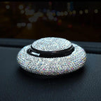 Crystal rhinestone car fragrance diffuser resting on a car dashboard at night