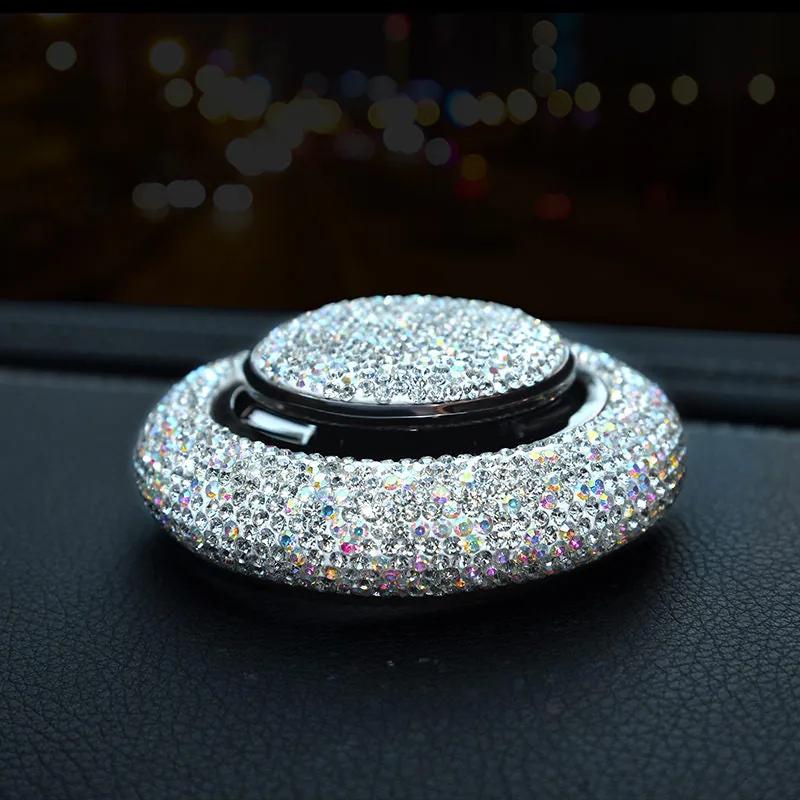 Crystal rhinestone car fragrance diffuser resting on a car dashboard at night