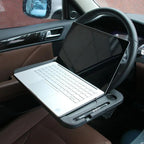 Steering wheel tray holding a laptop in the driver seat