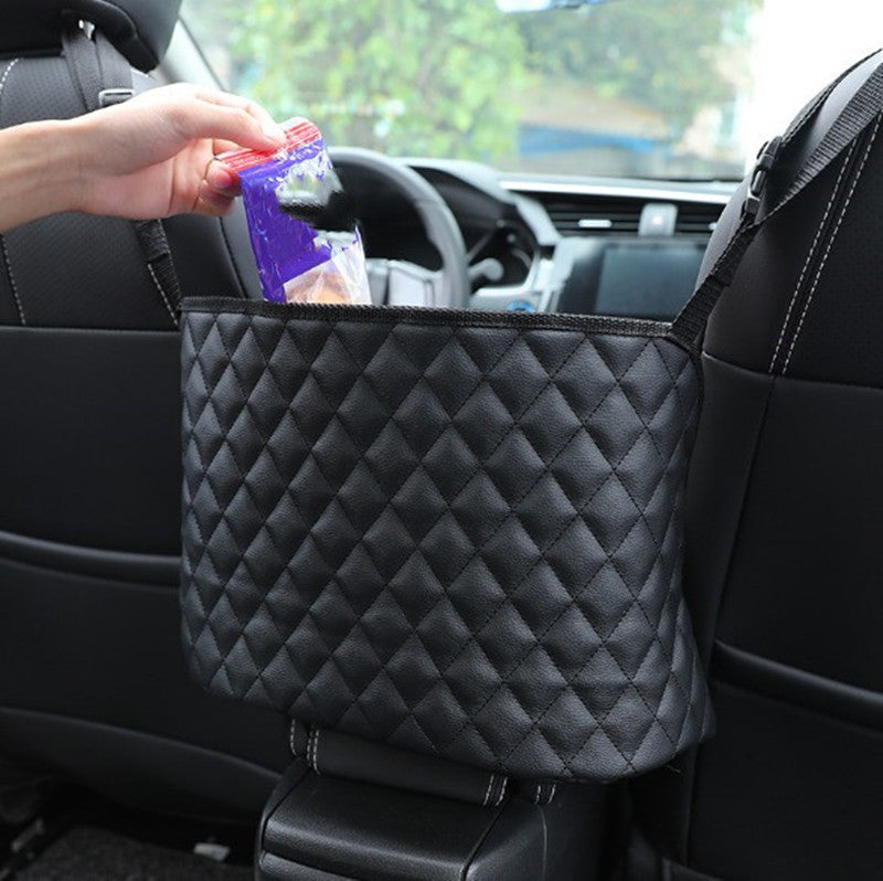 The quilted storage net hanging between the two front seats of a car, holding a snack
