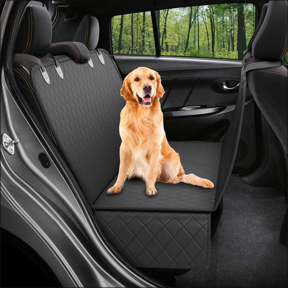 Golden retriever sitting on the black hammock seat cover across a car back seat