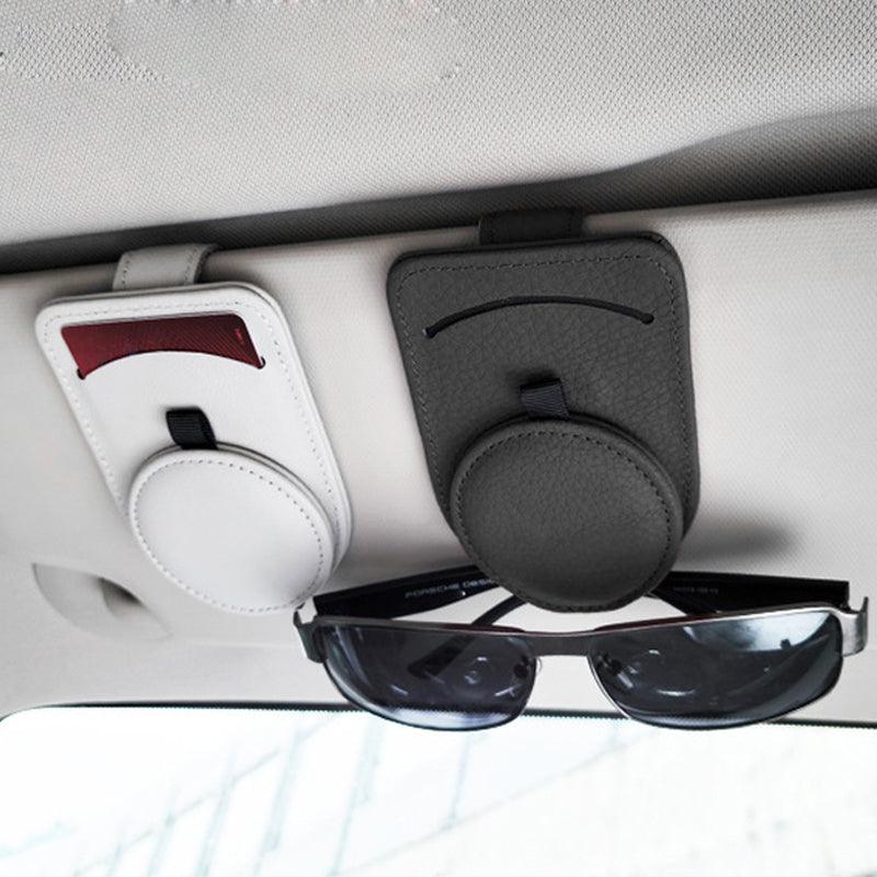 Leather visor clips mounted on a car sun visor holding sunglasses and a card