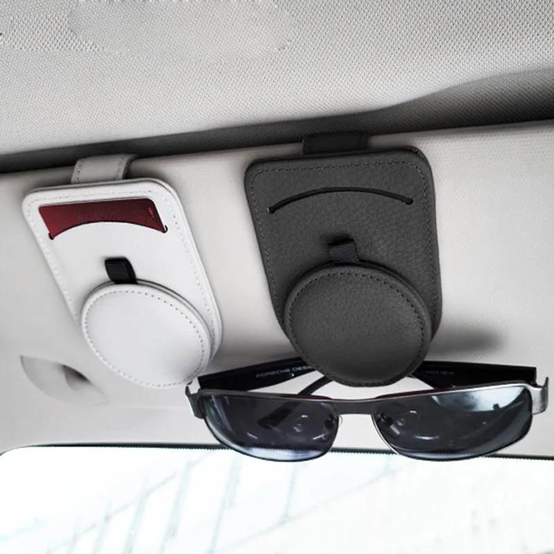 Leather visor clips mounted on a car sun visor holding sunglasses and a card