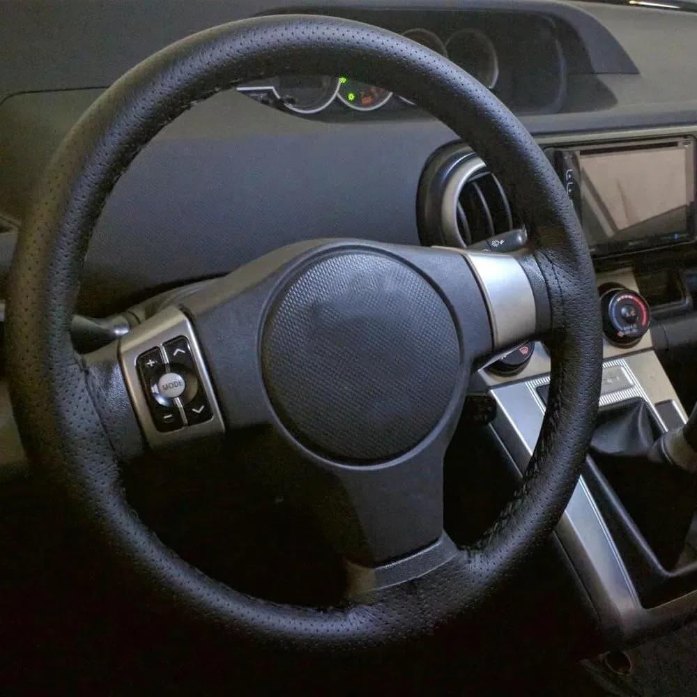 Lace-up leather car steering wheel cover fitted to the wheel, seen from the driver's seat