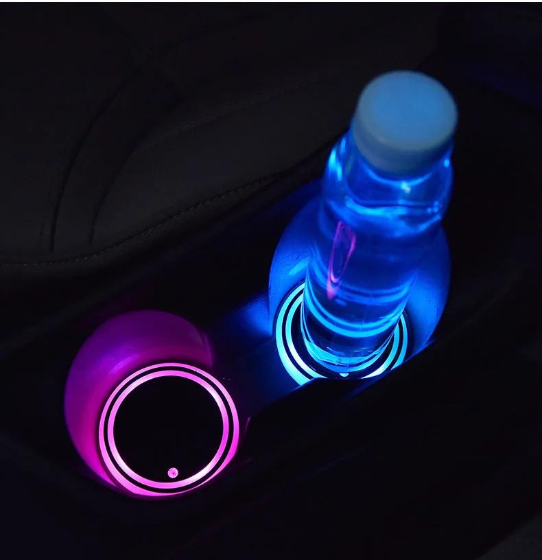 Night Drive Kit — LED coasters glowing blue and pink in the car cup holders at night