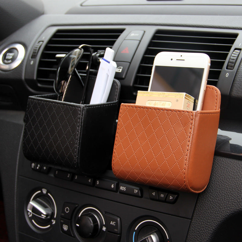 Leather vent pockets hooked onto a car air vent holding a phone, glasses and cards