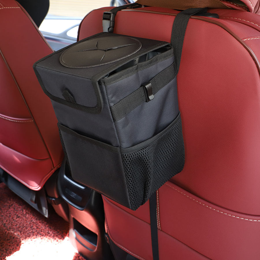 BinIt car trash can mounted on the seat back of a dark car interior