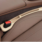 Beige — car seat gap filler strip fitted in the gap beside the seat, seat-belt buckle sitting in the moulded cutout