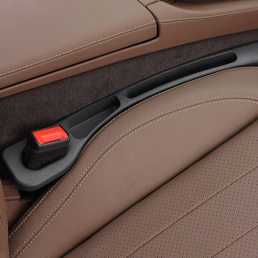 Black — car seat gap filler strip fitted in the gap beside the seat, seat-belt buckle sitting in the moulded cutout