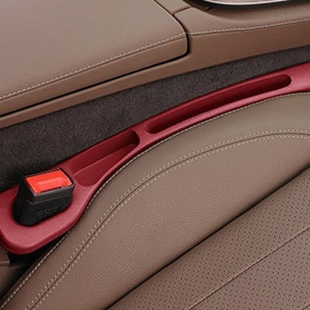 Volcano Red — car seat gap filler strip fitted in the gap beside the seat, seat-belt buckle sitting in the moulded cutout