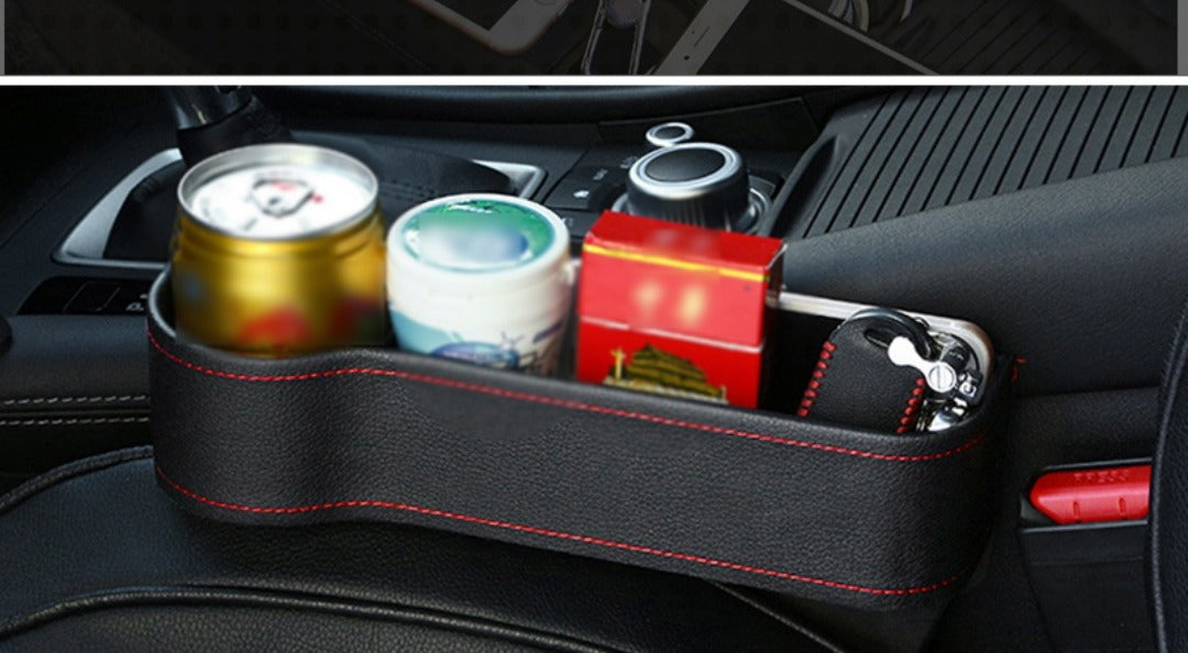 The gap box wedged between seat and console holding a can, a cup and a phone