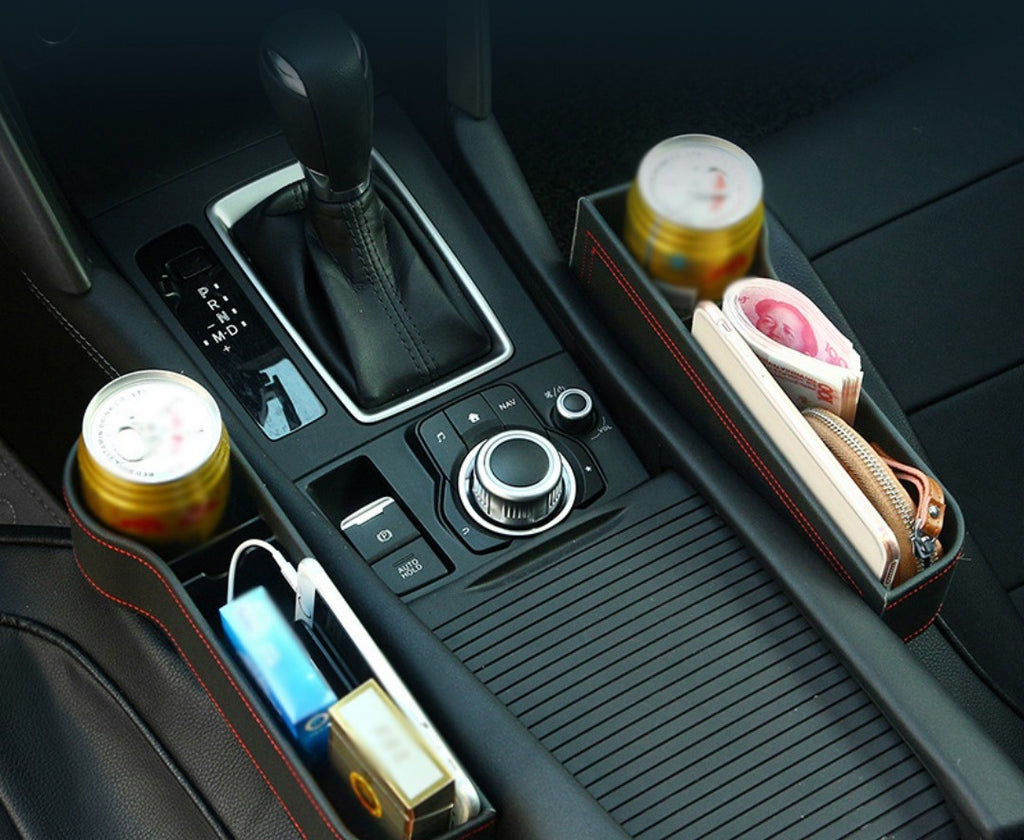 Two gap storage boxes fitted either side of the centre console, holding a drink, a phone and a charger