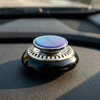 Kinetic solar car air freshener spinning on a car dashboard