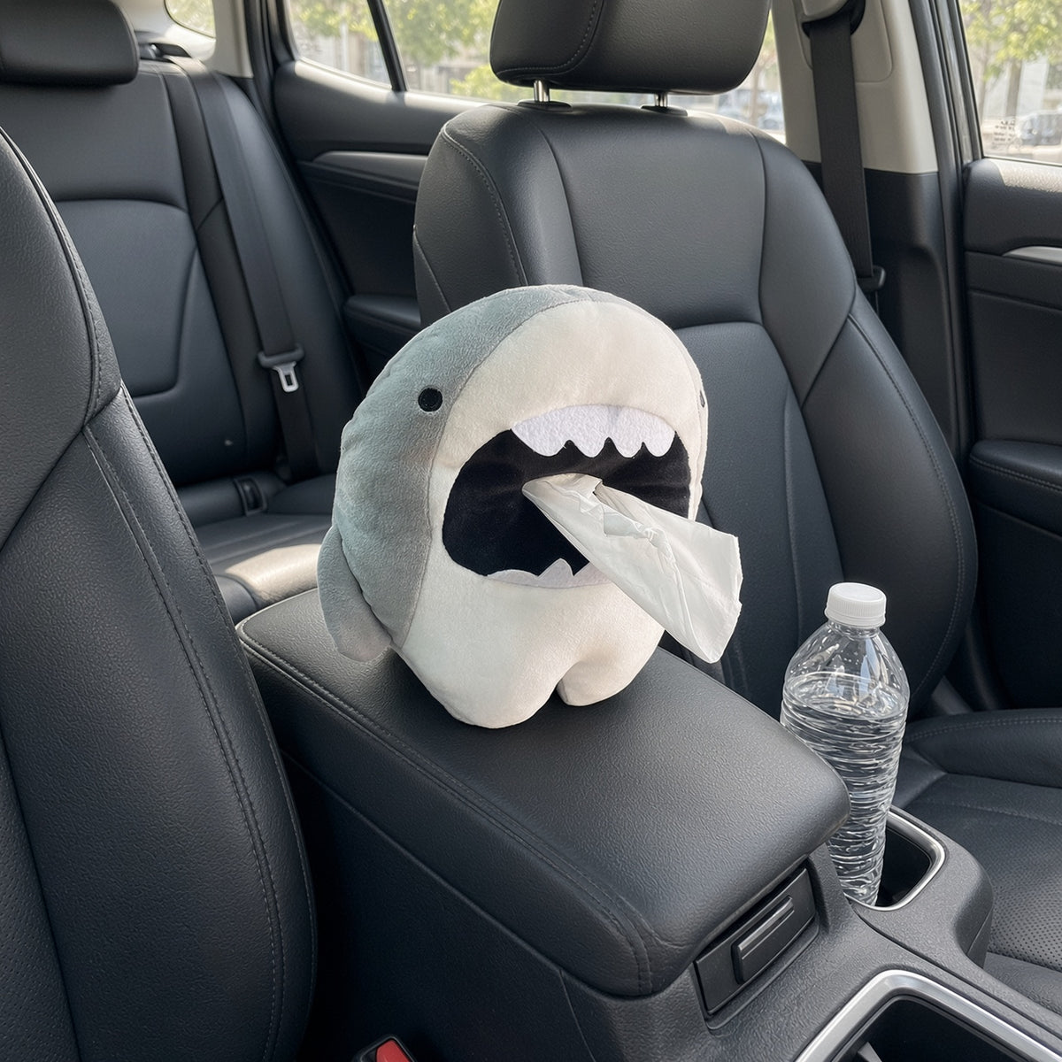 Shark car tissue box holder sitting on a centre console between the front seats, tissue pulled from the mouth