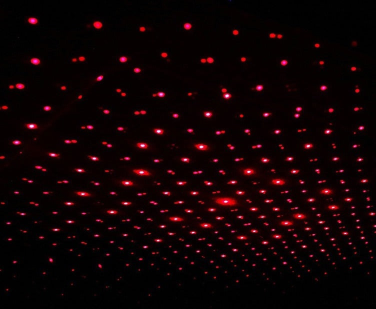 Red starfield projected across a car roof lining at night