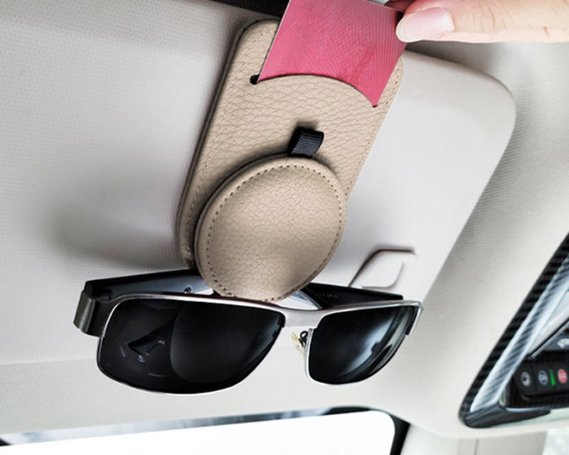 Car Sun Visor Sunglasses Holder in use — beige clip on the visor holding sunglasses while a hand slides a card into the slot