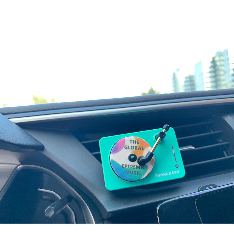 Record Player Car Vent Diffuser in use — green unit clipped to a dashboard air vent