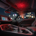 USB galaxy car roof star projector plugged into the centre console USB beside the gear shifter, throwing red starlight across the car roof lining at night